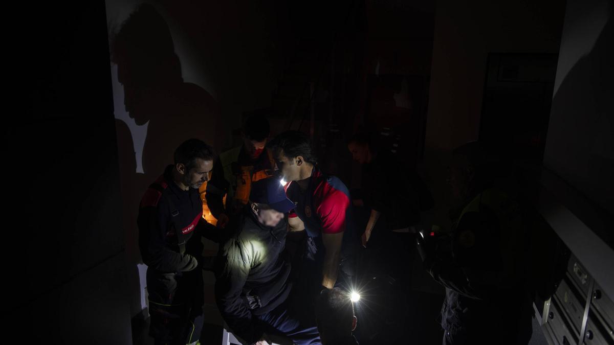 Los bomberos bajan a una persona con movilidad reducida, en una finca de València.
