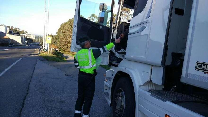 Un agente requiere la documentación a un transportista en una carretera gallega durante un control.
