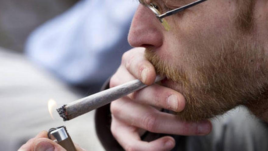 Un joven fumando un cigarrillo de marihuana.