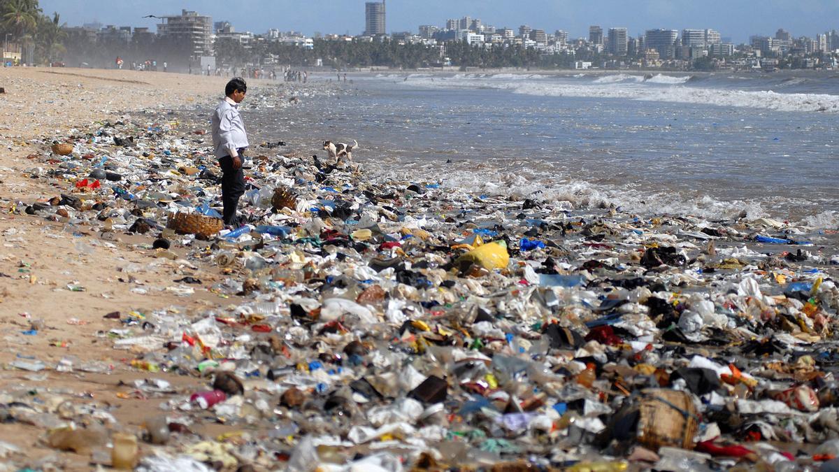 Un hombre observa una montaña de residuos plásticos a orillas del Mar Arábigo en Bombay, India.