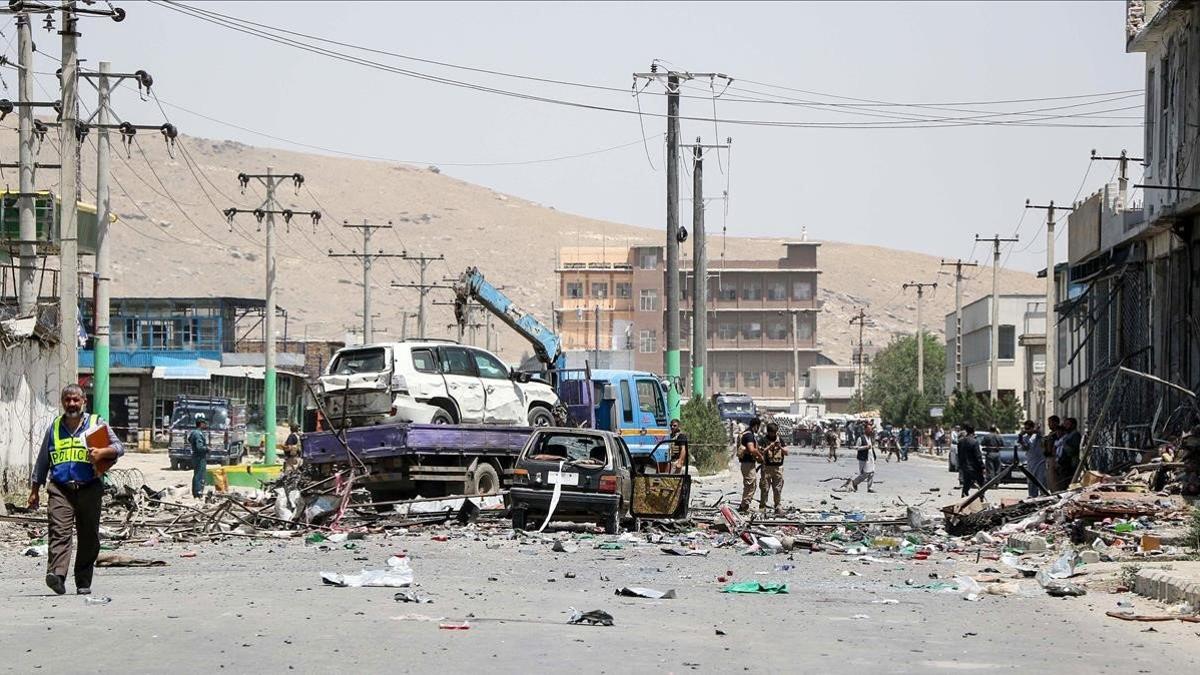Personal de seguridad afgano retira un vehículo dañado en un atentado suicida en Kabul el 25 de julio de 2019