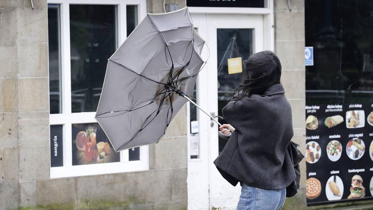 Una mujer pelea contra el viento en Santiago para mantener su paraguas