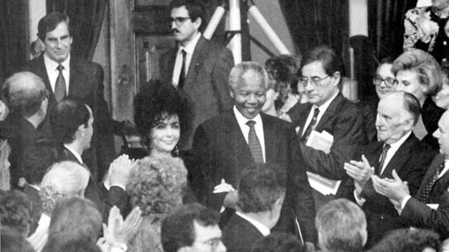 Mandela con Elizabeth Taylor, en el teatro Campoamor de Oviedo durante la entrega de los premios «Príncipe de Asturias» de 1992. A la izquierda, Mandela en el Mundial de Sudáfrica de 2010, que ganó España. | la nueva españa / reuters