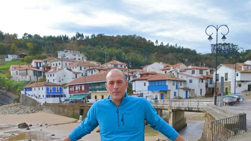 Emilio Busto, con el puerto de Tazones a su espalda.