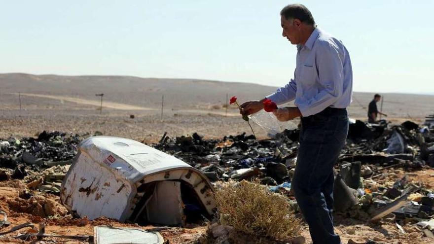 Un ciudadano egipcio deja una flor en una de las zonas donde cayeron restos del avión. // Reuters