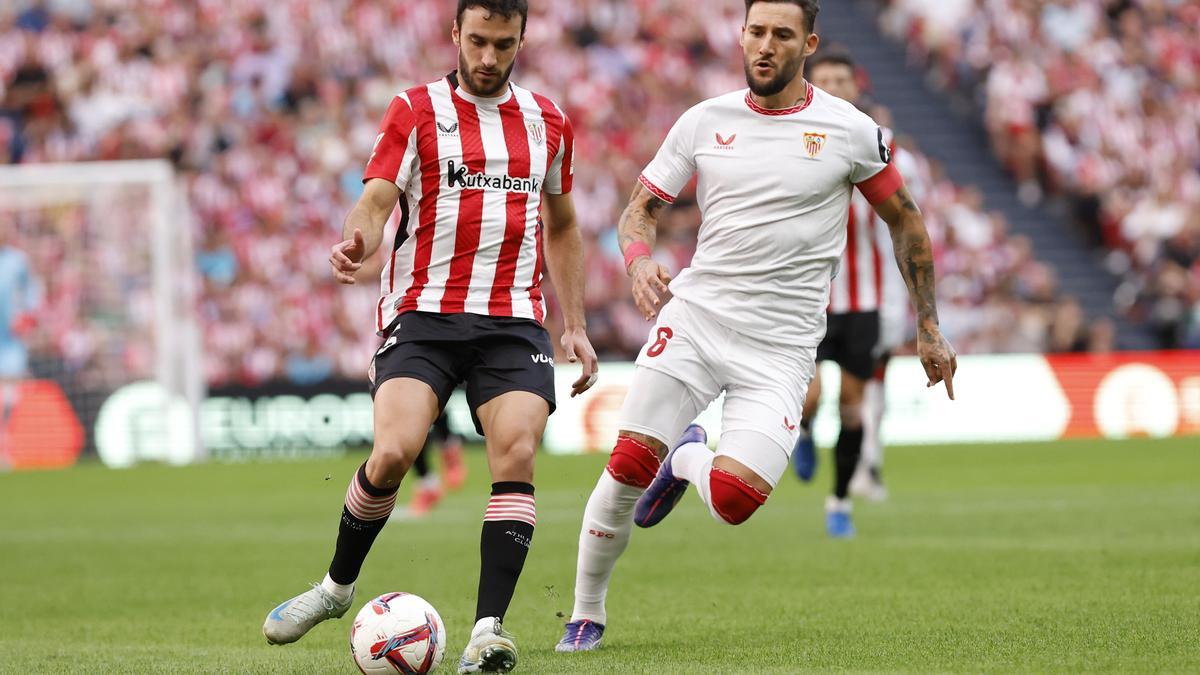 BILBAO (ESPAÑA), 29/09/2024.- El defensa del Athletic de Bilbao, Íñigo Lekue (i) lucha por el balón con el centrocampista serbio Nemanja Gudelj (d) del Sevilla FC durante el partido de LaLiga contra el Sevilla este domingo en el estadio San Mamés en Bilbao. EFE/ Miguel Tona