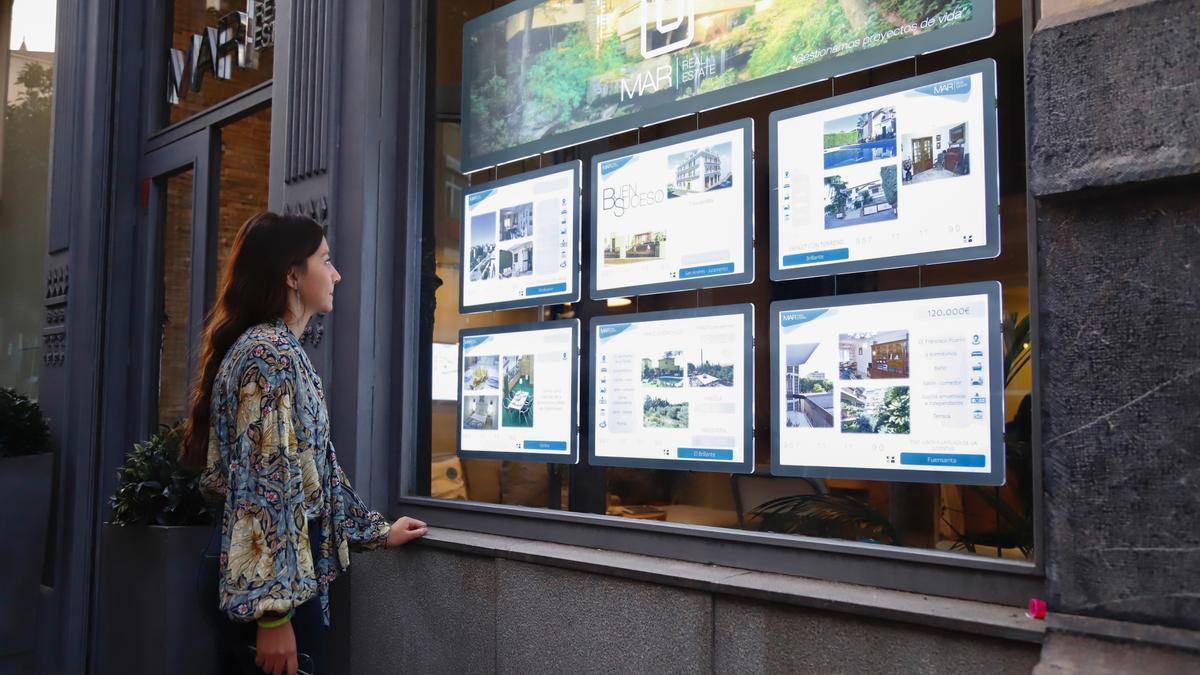 Una joven mira los precios en una inmobiliaria de Córdoba.