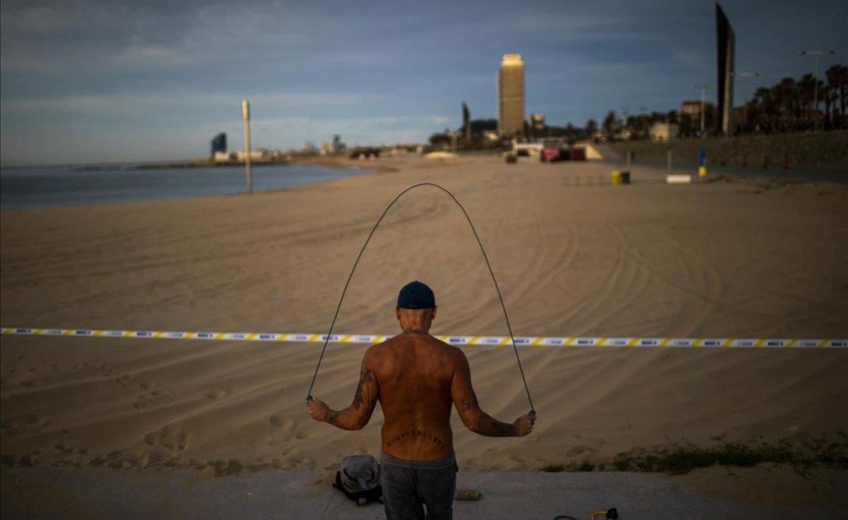 Un hombre salta a la comba en la playa de Barcelona.