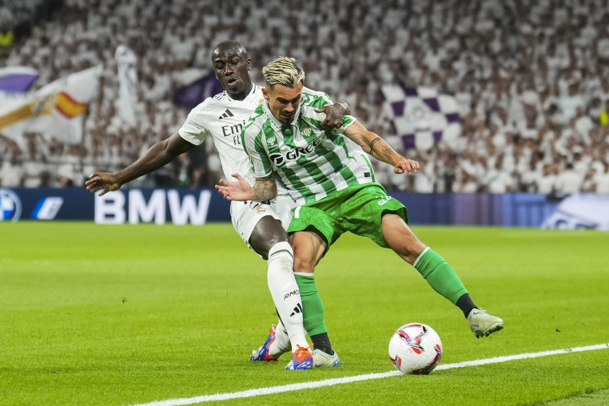 MADRID, 01/09/2024.- El dfensa del Real Madrid Ferland Mendy (i) lucha con Rodrigo Sánchez, del Betis, durante el partido de la cuarta jornada de LaLiga entre el Real Madrid y el Real Betis, este domingo en el estadio Santiago Bernabéu. EFE/Borja Sánchez-Trillo