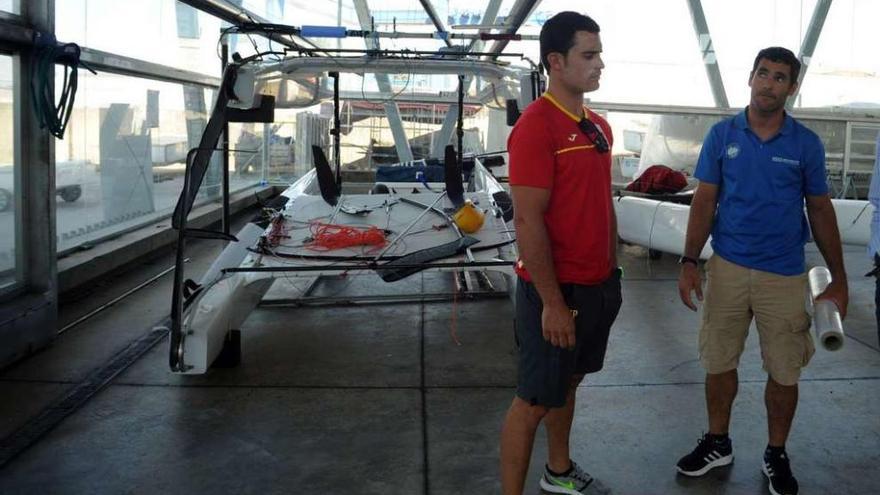 Antón Paz (derecha) ante el casco del Clase A que utiliza en las dependencias del Centro Galego de Vela de Vilagarcía. // Iñaki Abella