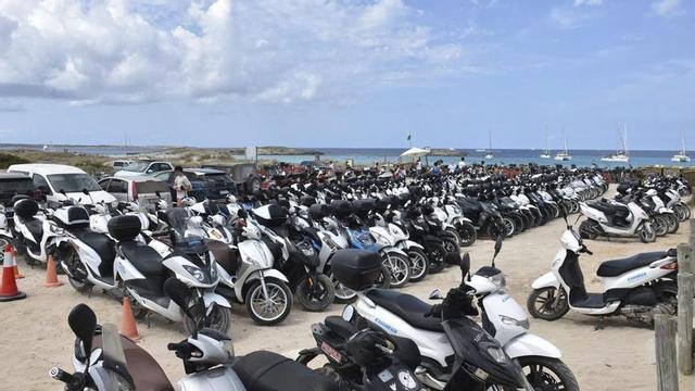 Motos, en su mayoría de alquiler y por tanto no sujetas al cupo de vehículos de turistas ni de ibicencos, en un aparcamiento de ses Illetes. | CÉSAR NAVARRO
