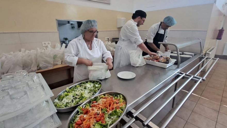 Por la izquierda, Puri Montes, Iván Tiberiu y Ángel Fandiño, preparando comidas en la sede de Amicos. | D. M.
