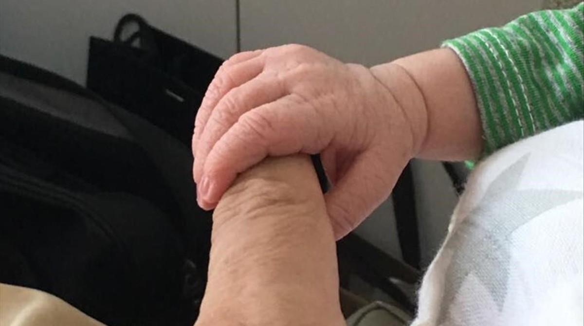 El recién nacido Ibai se agarra, con su robusta mano derecha, al dedo índice izquierdo de su abuelo Andoni Zubizarreta.