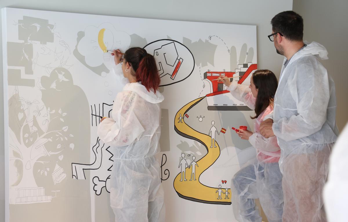 Trabajadores de la empresa con sede en Nigrán pintando uno de los paneles.