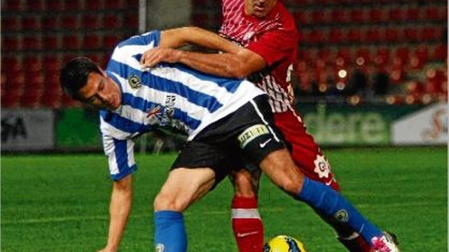 Migue pugna amb un jugador de l&#039;Hèrcules per la pilota durant el partit de dissabte a Montilivi.