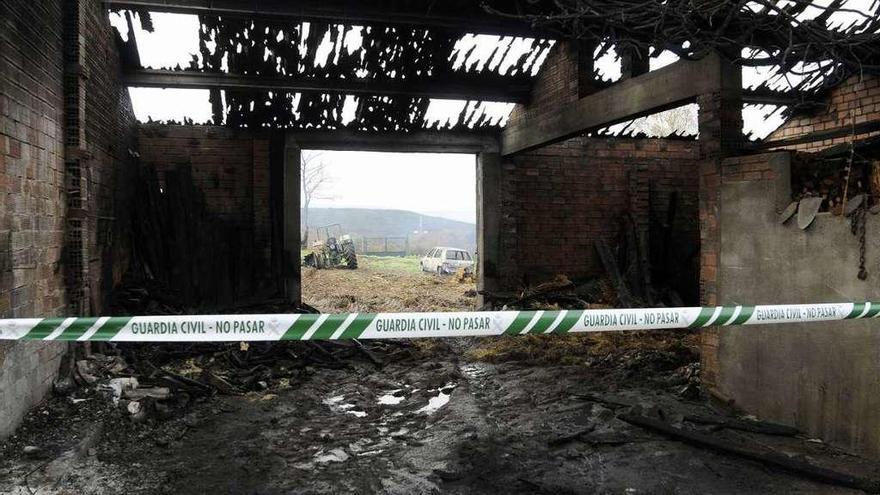 Una vista del alpendre calcinado en Donsión, ayer, con la maquinaria en su parte trasera. // Bernabé/J. Lalín