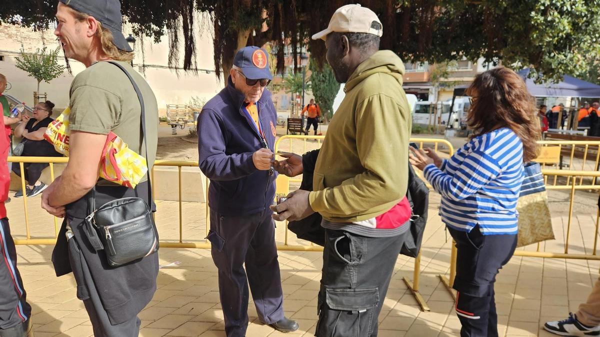 Un voluntario comprueba la identidad de las personas en la cola.