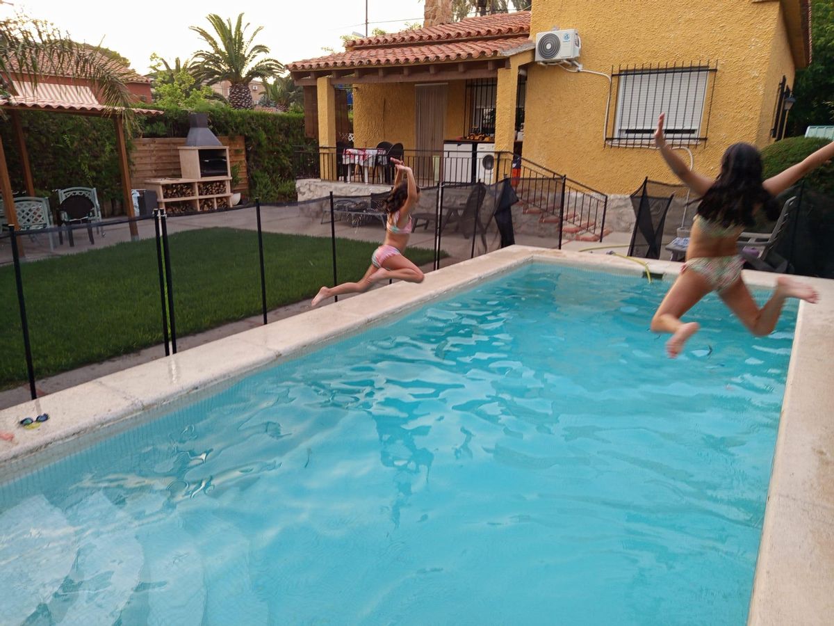 Las hijas de María Blanco en la piscina de la casa de Valencia que han reservado por Home Exchange.