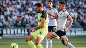 Stuani controla un balón ante la vigilancia de los jugadores del Burgos.