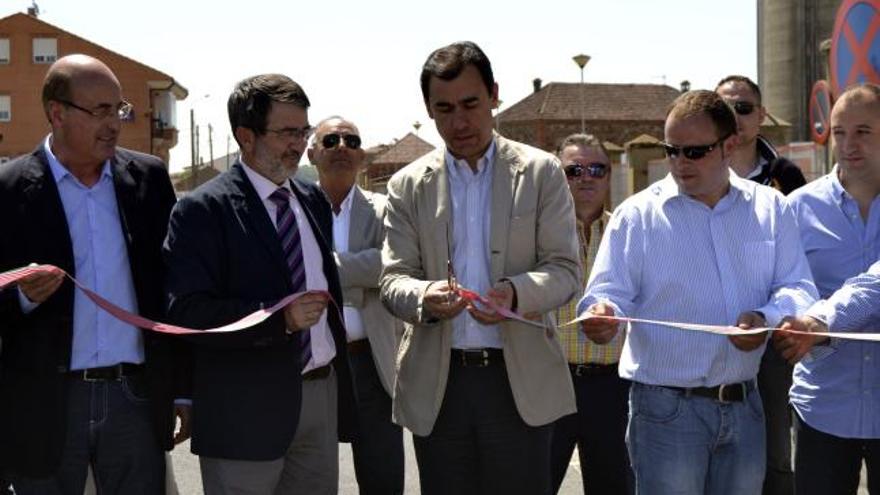 Maíllo, en el centro, junto a los alcaldes de Benavente y Villanueva, corta la cinta de inauguración de las obras.