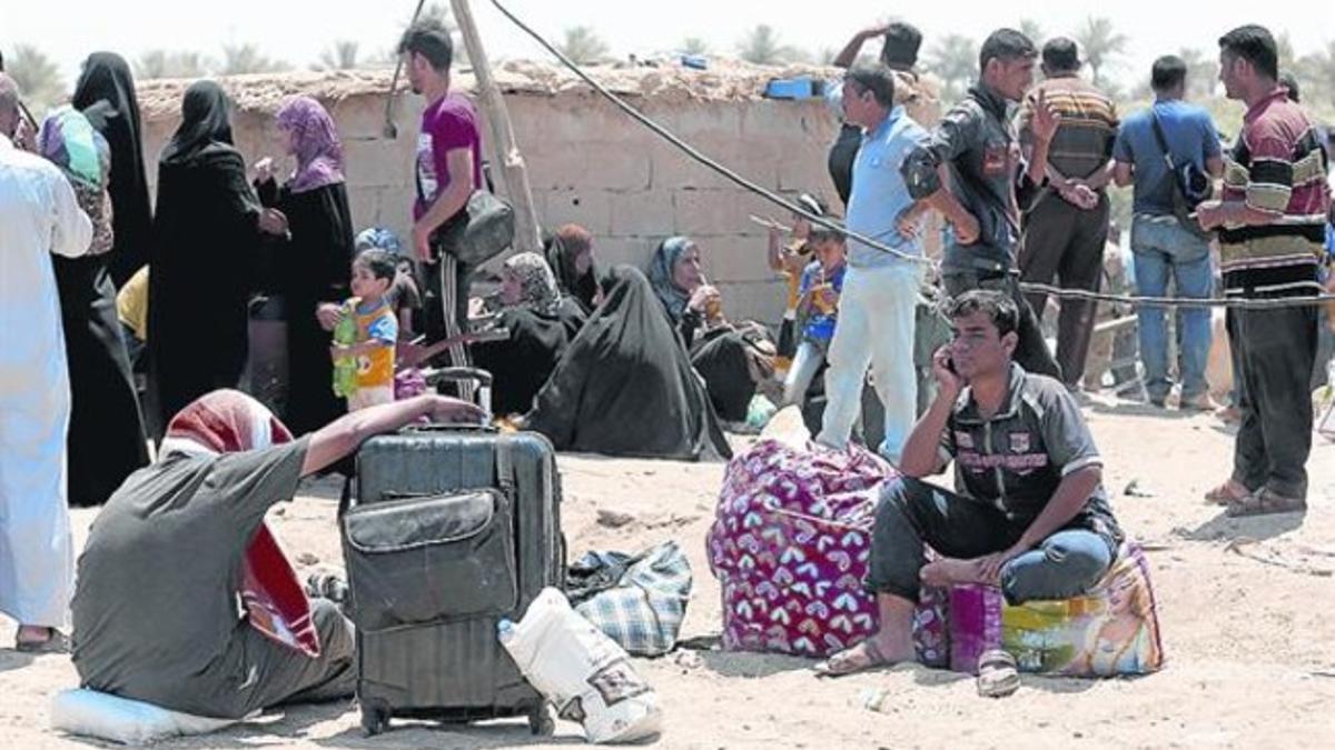 Un grupo de sunís en las cercanías de Bagdad tras huir de la violencia de Ramadi, ayer.