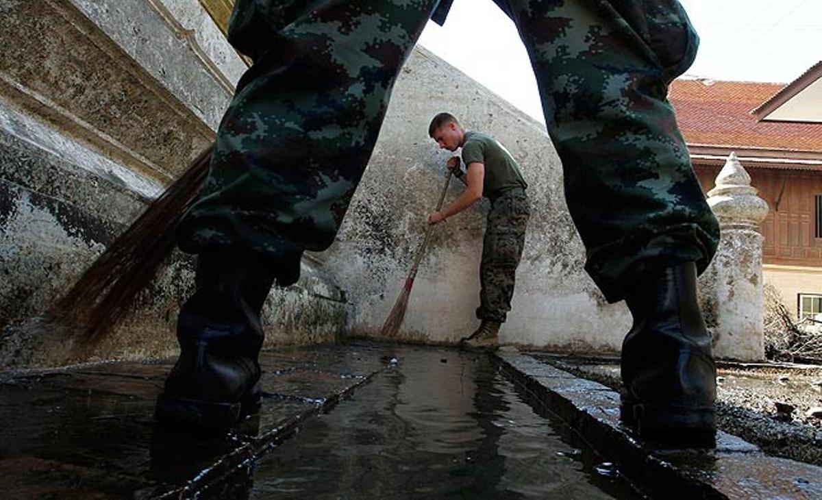 Dos soldats netegen un temple inundat a Sukplang, Tailàndia.