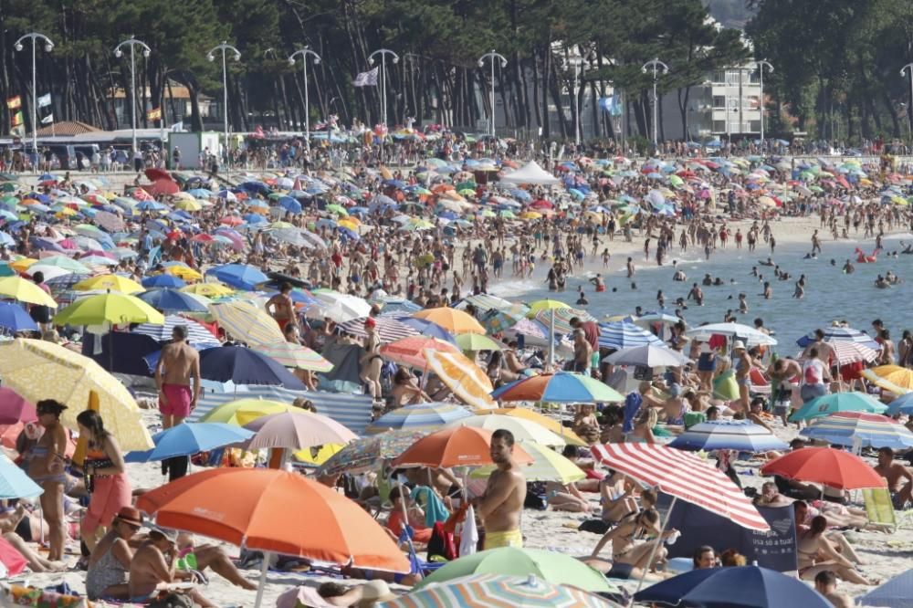 El buen tiempo anima a los bañistas en la playa de Samil