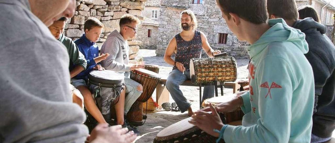 Un grupo de alumnos sigue las instrucciones de su profesor durante el taller de música africana. // Bernabé