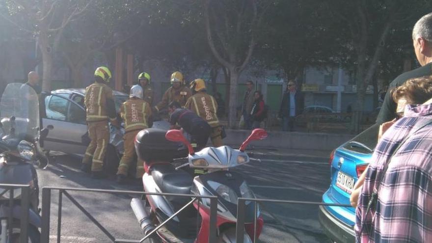 Los bomberos han dado la vuelta al coche volcado para retirarlo de la vía