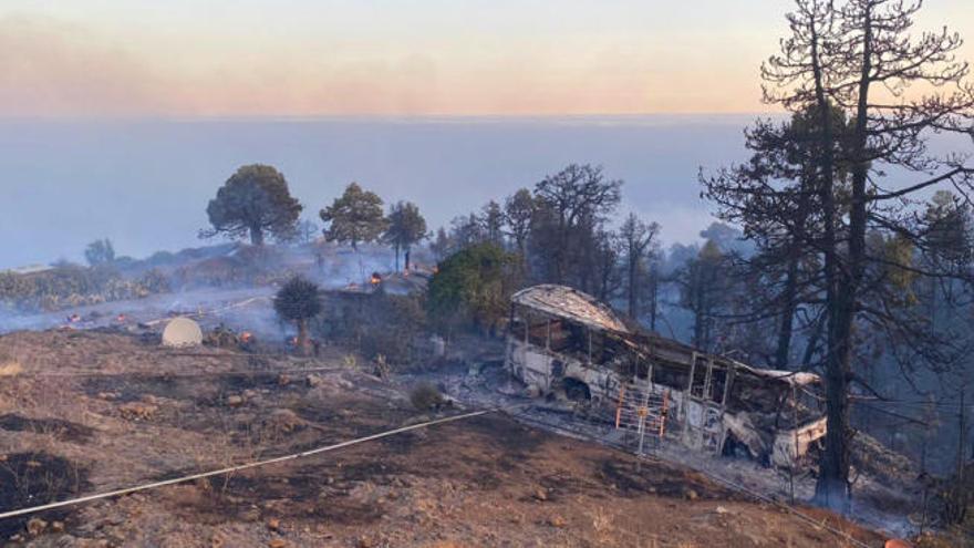 Una guagua aparece al lado de una vivienda en Garafía, en una zona calcinada por el incendio forestal que afectó al municipio norteño de La Palma.