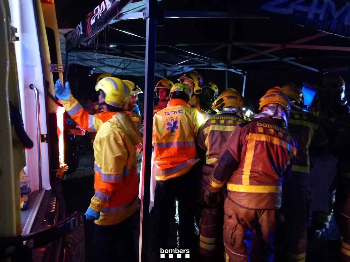 Bombers i SEM carregant el ferit a l'ambulància