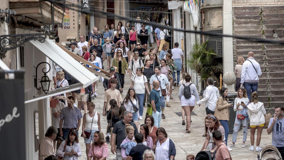 Residentes y turistas en el centro de Palma.