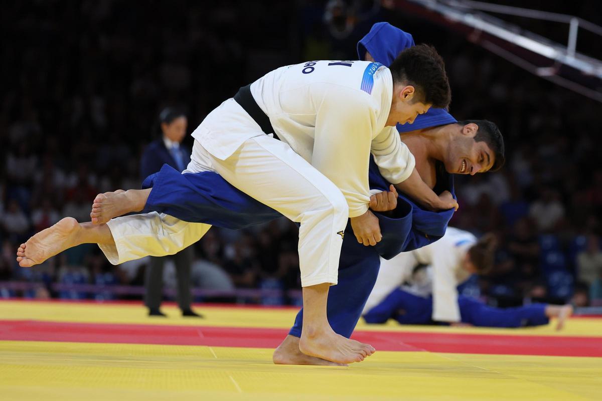 El español Tristani Mosakhlishvili (azul) durante su combate contra el japonés Sanshiro Murao durante la ronda eliminatoria de judo por equipos mixtos en los Juegos Olímpicos de París 2024, este sábado.
