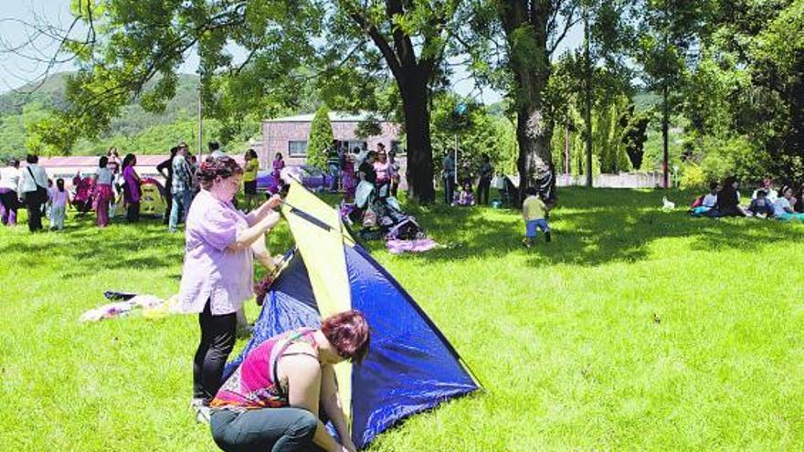 Dos vecinas instalan una de las tiendas de campaña en las proximidades del polideportivo de Riaño.