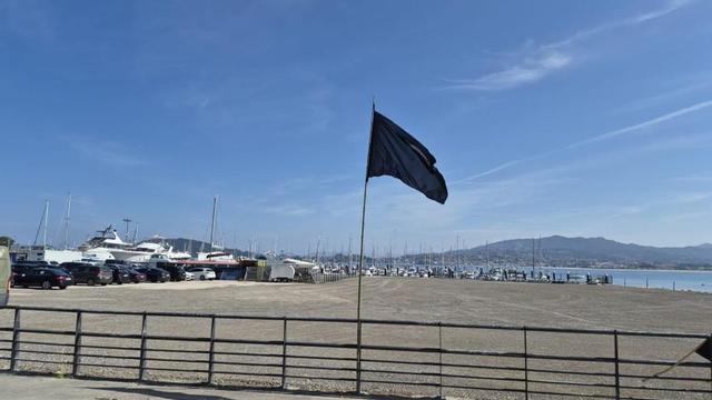 La bandera negra de Ecoloxistas en Acción, ayer, en el puerto deportivo. |