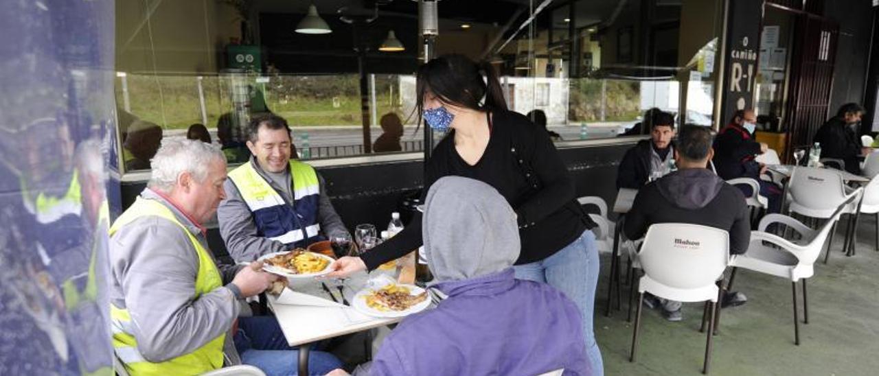 Una camarera sirve la comida a un grupo de clientes en un restaurante de Silleda. |   // BERNABÉ/JAVIER LALÍN