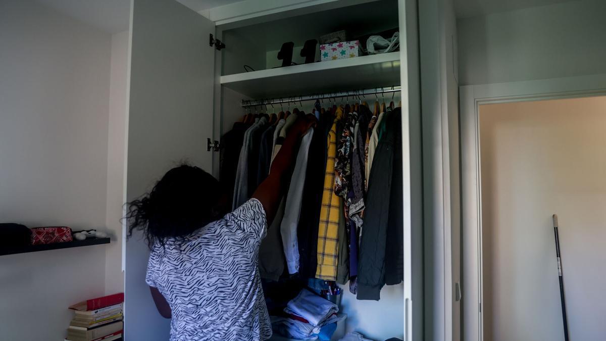 Una treballadora de la llar organitza la roba de l'armari