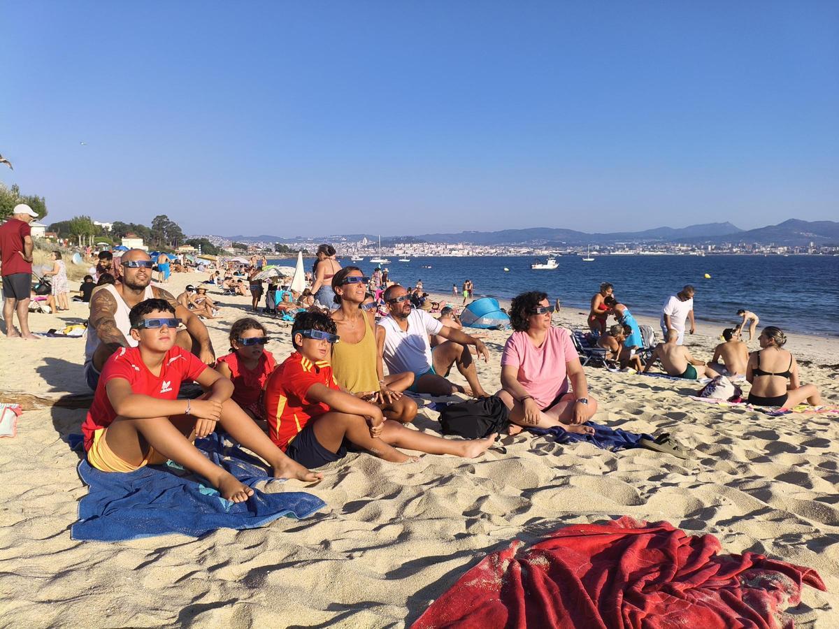 Una familia madrileña contemplando el eclipse en la playa de Rodeira.