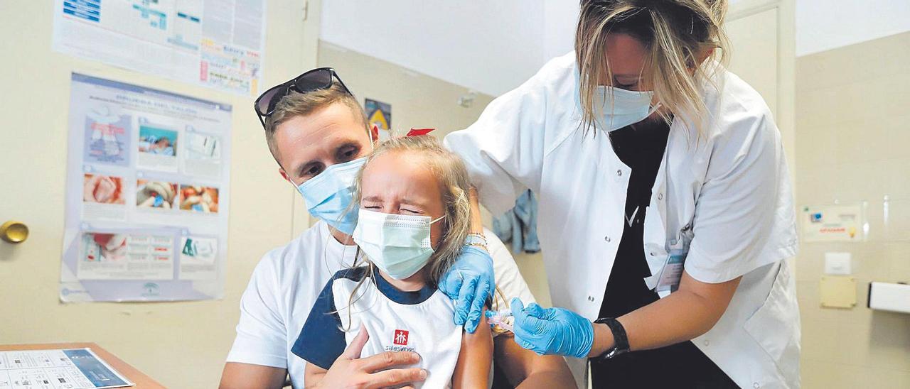 Una niña de corta edad recibe la vacuna frente a la gripe en el centro de salud Fuensanta de Córdoba.