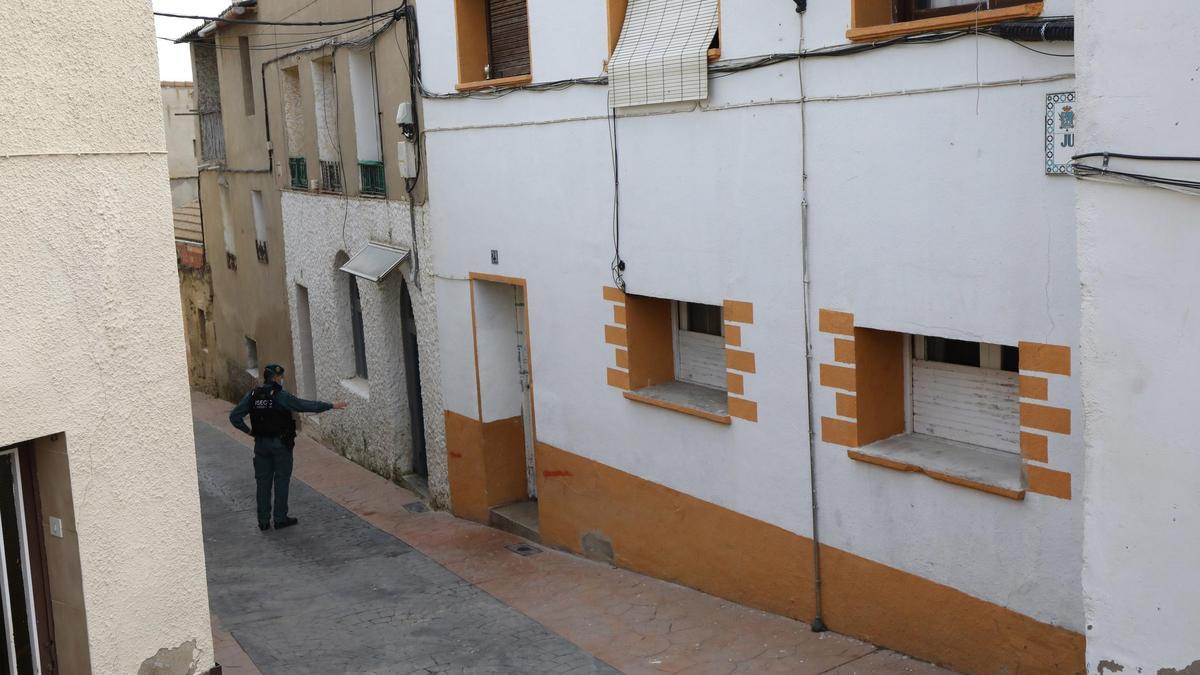 Un agente de la Guardia Civil señala la puerta de la vivienda donde ocurrió el crimen, todavía con manchas de sangre.