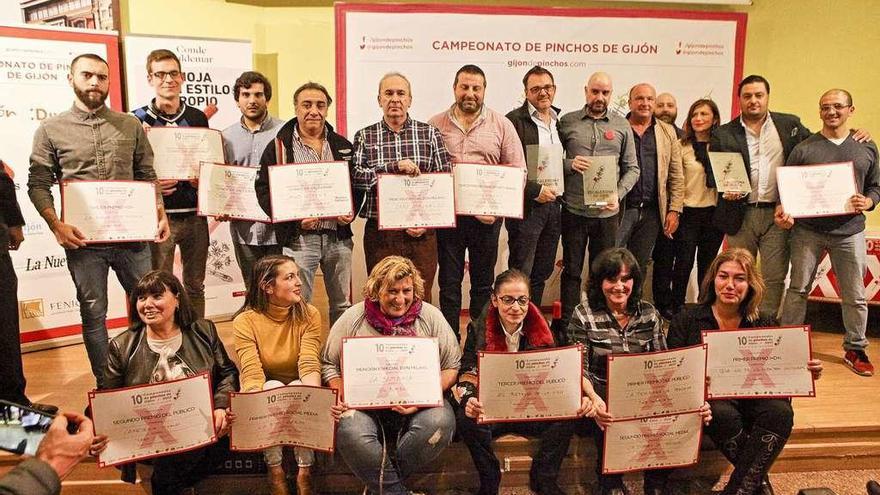 Foto de familia de todos los premiados en el X Aniversario del Campeonato de Pinchos de Gijón, con los tres vencedores en la categoría general de pie, mostrando sus galardones.