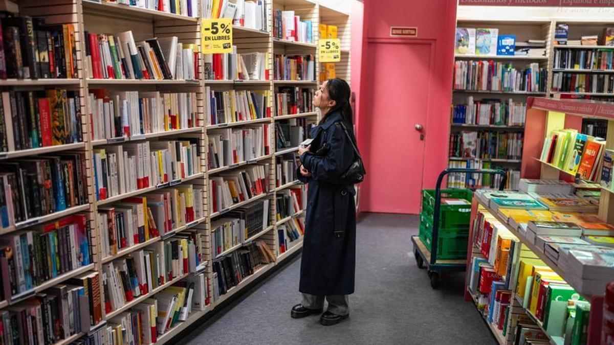 Una mujer observa los libros en una librería.