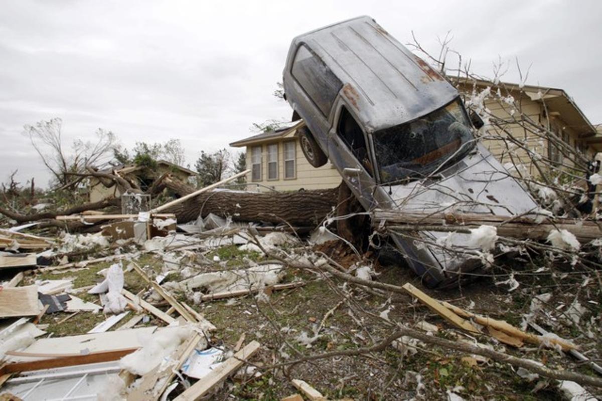Un vehicle sobre un arbre, després del pas d’un tornado per la localitat de Tushka, a Oklahoma, divendres.