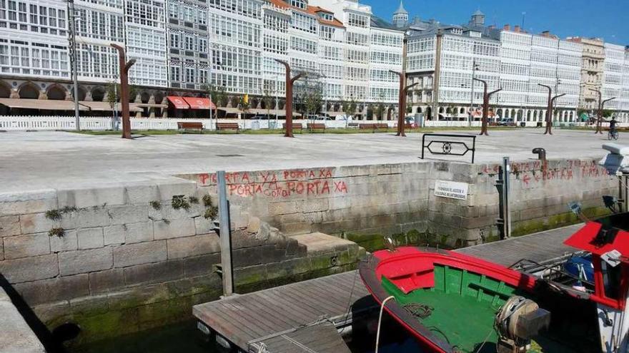 Las escaleras por las que se accede al muelle, con pintadas en las que se exige que se coloque una puerta.