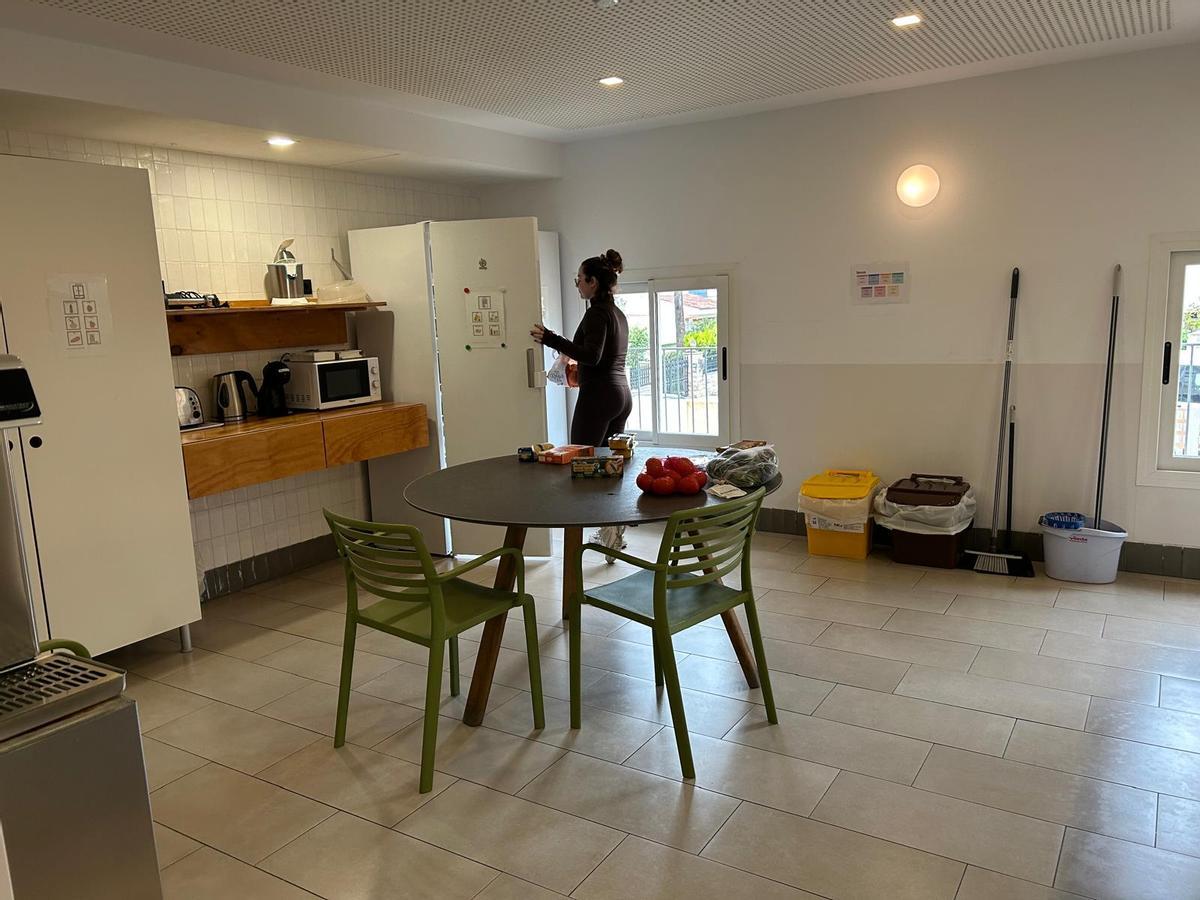 Una de las gestoras del hogar coloca la compra en la cocina común.