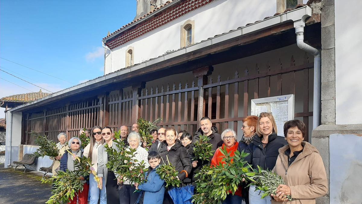 Una treintena de vecinos de Folgueras, en Pravia, bendicen sus ramos rezando ante la iglesia ante la ausencia del párroco. Imagen y foto Luján Palacios