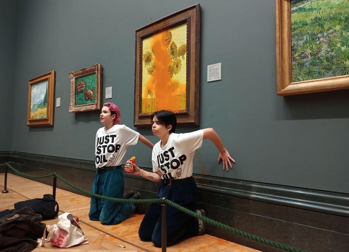 Dos activistas de Just Stop Oil tras lanzar sopa de tomate en el cuadro de Los Girasoles de Van Gogh, en la National Gallery de Londres, el 14 de octubre de 2022.