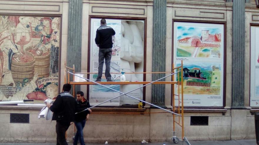 Dos operarios cambiando algunas de las fotografías.