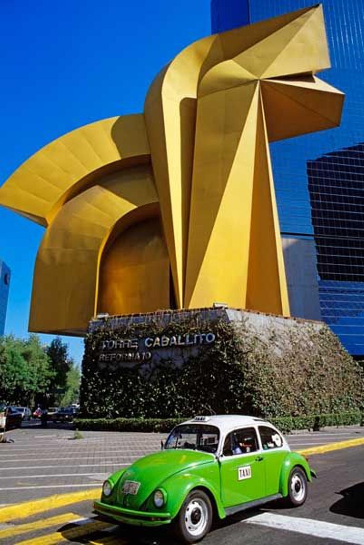 Taxi frente a la escultura llamada El Caracol en el Paseo de la Reforma.