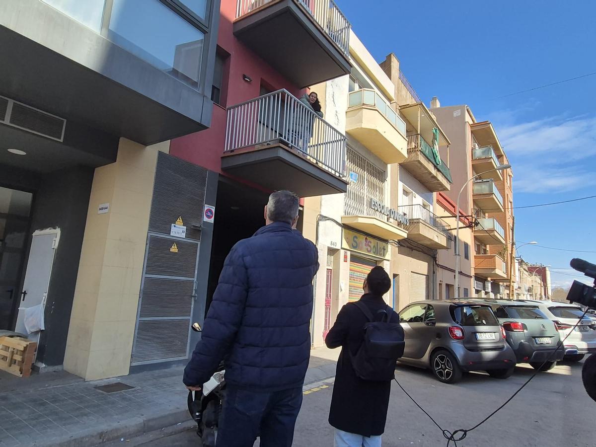 El alcalde de Badalona, Xavier García Albiol, hablando con la ocupante asomada al balcón, antes de abandonar el piso este domingo.